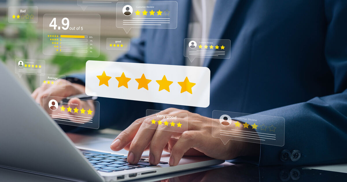 A business owner at a laptop surrounded by five-star Google review cards